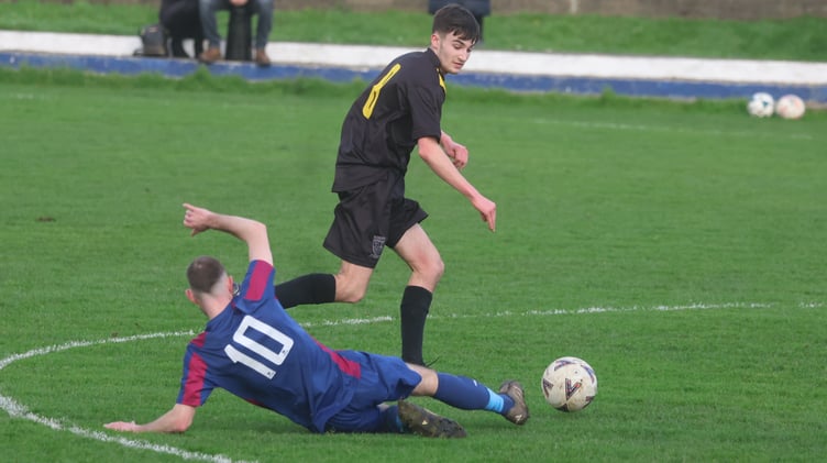 Ramsey's Nathan Craine evades Foxdale's Liam Cannan's sliding challenge during Saturday's Canada Life Premier League clash at Ballacloan Stadium (Photo: Paul Hatton)