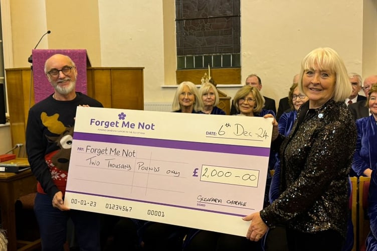A cheque of £2,000 is presented to 'Forget Me Not' from the Glenfaba Chorale