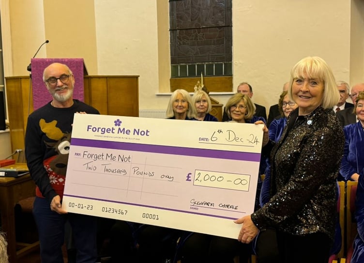 A cheque of £2,000 is presented to 'Forget Me Not' from the Glenfaba Chorale