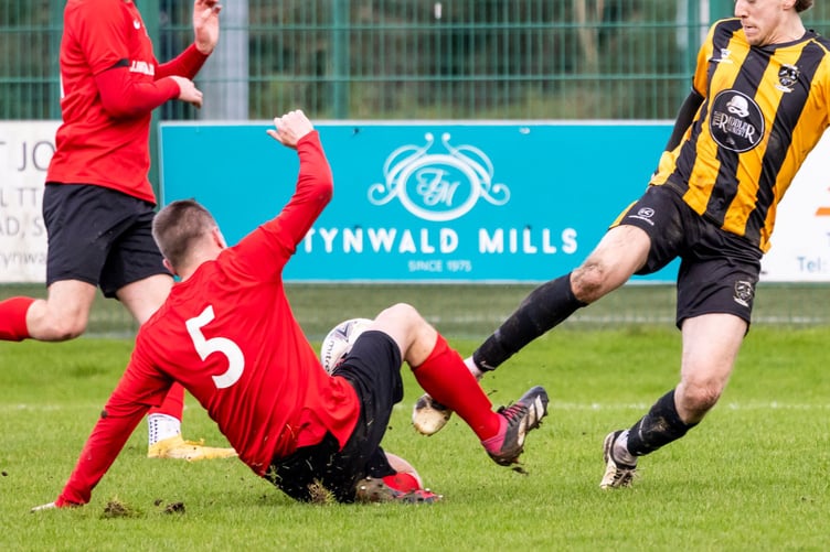 Rushen United's Jamie Cadwallader (right) challenges a St John's defender for the ball during the two sides' FA Cup meeting last weekend. Cadwallader starred for the Spaniards with two goals to earn his place in Team of the Week (Photo: Gary Weightman)