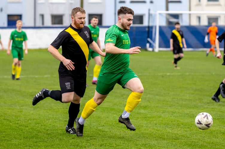 Joe Bergquist of St Mary's attempts to escape the attentions of Ramsey's Greg Hepburn during last Saturday's Canada Life Premier League clash at Ballacloan Stadium. Sporting Ramsey's special 140th anniversary strip, Hepburn impressed to earn his place in the latest Team of the Week (Photo: Gary Weightman)