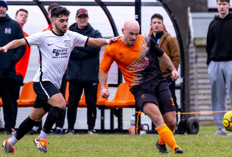 Ayre United's Johnny Shields (right) releases the ball under pressure from Corinthians' Joao Marques during last weekend's ECAP FA Cup clash in Andreas. Shields impressed to earn his place in the latest Team of the Week (Photo: Gary Weightman)