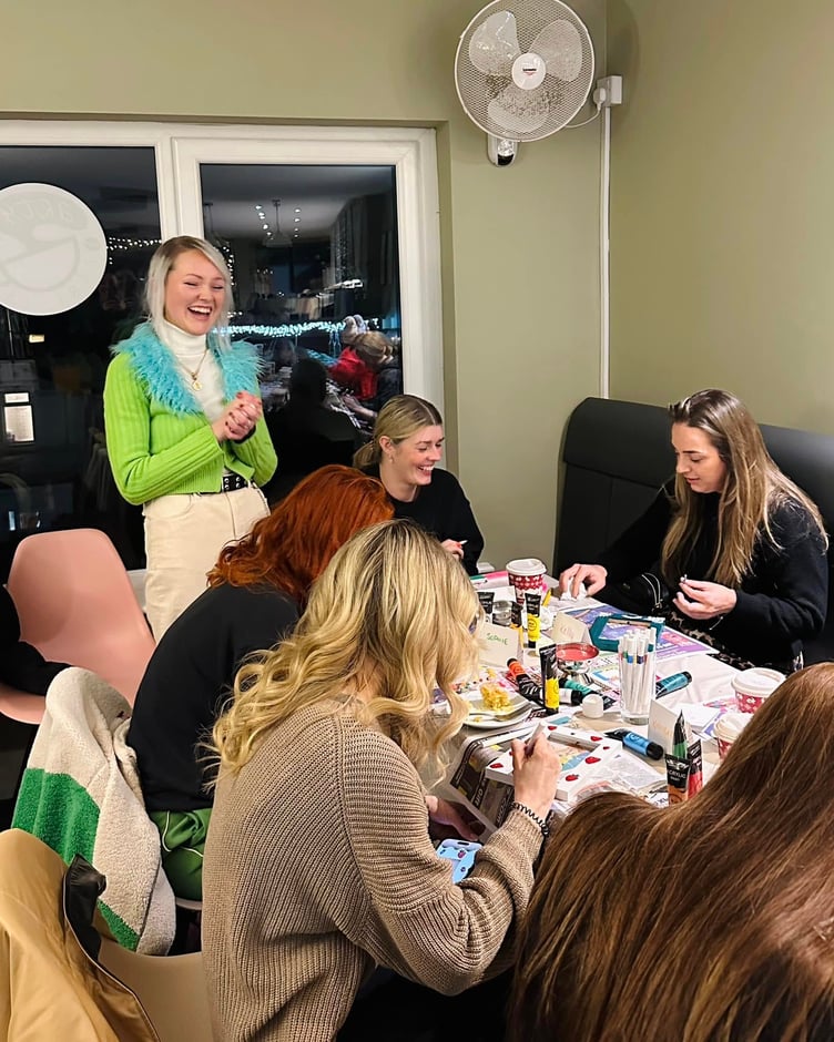 Natalie Bruynseels overlooking the first frame painting workshop at Arty Barista in Onchan