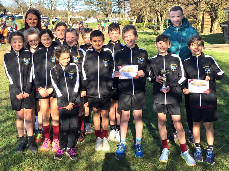 Children from the winning school, Rushen Primary, with the trophy alongside Manx athlete Ollie Lockley and Susie Faragher from sponsor Manx Building Contractors at last week's Cross-Country Championships at Noble’s Park (Photo: Peter Lewis)