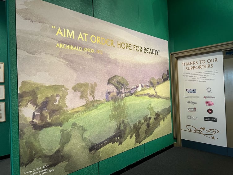 The entrance walkway, with one of Knox's pictures and the phrase 'aim at order, hope for beauty'