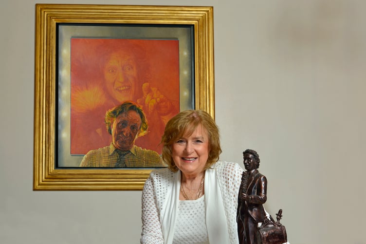 Anne, Lady Dodd, with portrait of the late Sir Ken Dodd