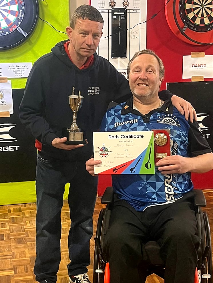 Isle of Man darter Darren Kennish receives his Winmau Open prizes from Karl Holden representing sponsor St Helens Darts Shop