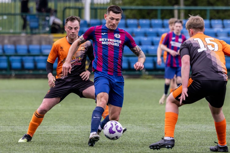 Foxdale's Lee Gale attempts to escape the attentions of Ayre's Harry Best at the Bowl (Photo: Gary Weightman)