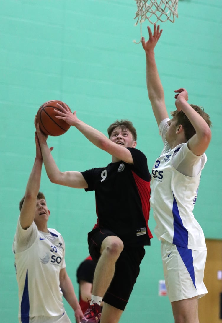 Ravens' Matthew Jones goes to the hoop against the defence of Cannons' Jack Wilkinson (right) and Rowan Coulter (Photo: Martin Dunne)
