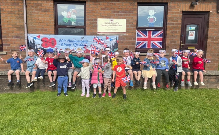 St Joseph's line up in front of flags and banners