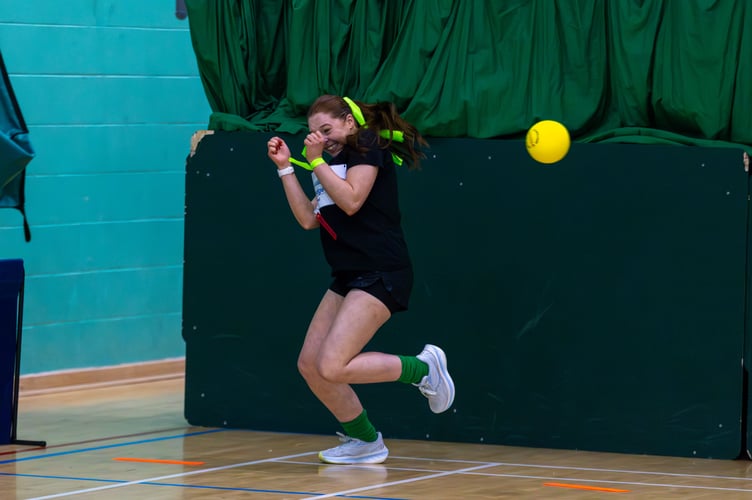 One player gets out of the way of one of the balls
