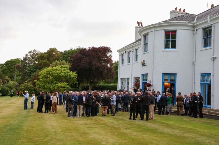 The crowds spilled outside at Government House to watch the Red Arrow perform a spectacular air display above Douglas Bay