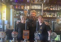 Noel Edmonds all smiles as he poses with pub staff during latest visit to island