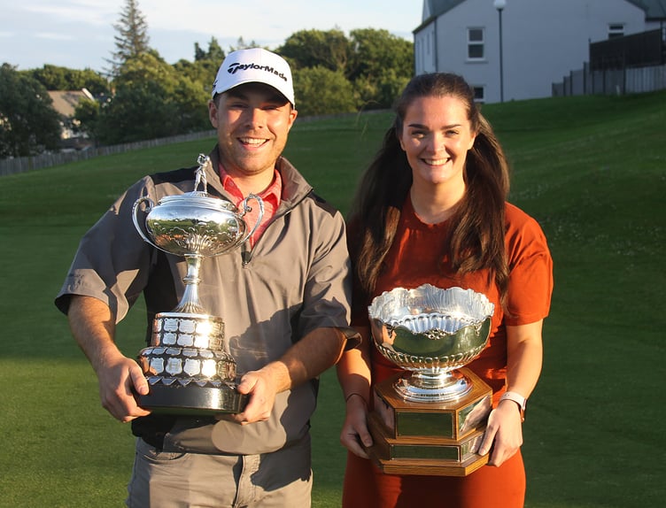 Tommy Fenlon and Kayleigh Dawson with their impressive island golf championship trophies after winning the delay finals at Mount Murray on Tuesday evening