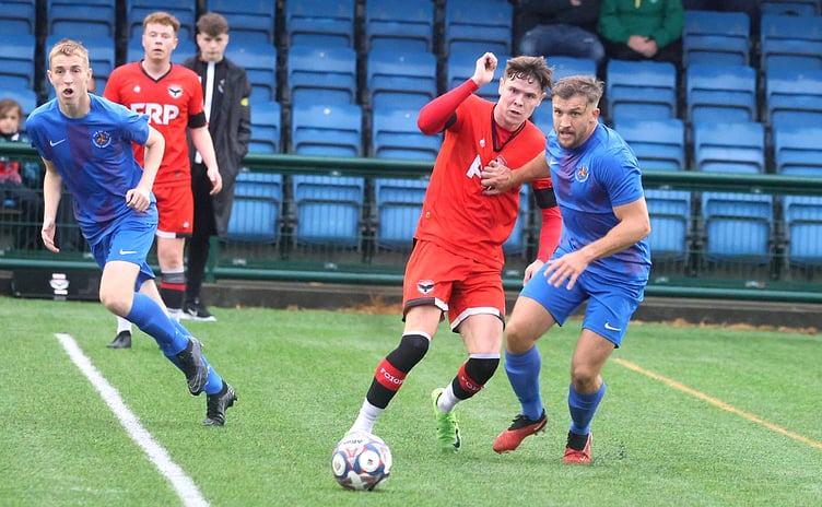 FC Isle of Man's Charlie Higgins (centre) competes for the ball with Isle of Man FA player Sammy Gelling during last Friday's friendly at the Bowl (Photo: Paul Hatton)