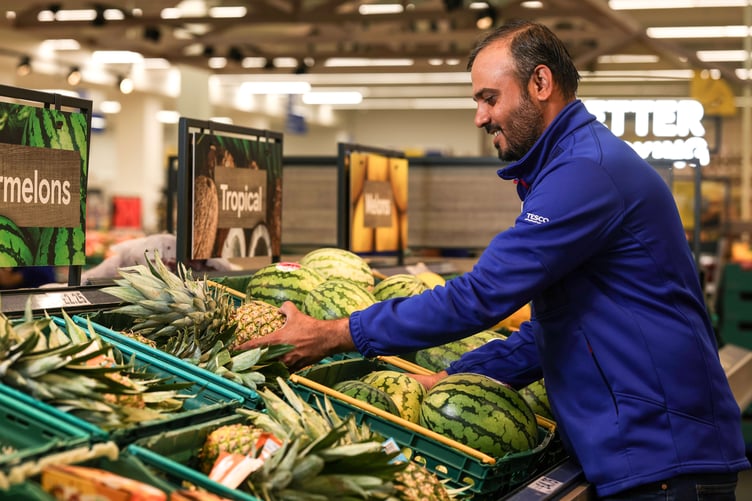 Tesco worker packing up fruit and veg