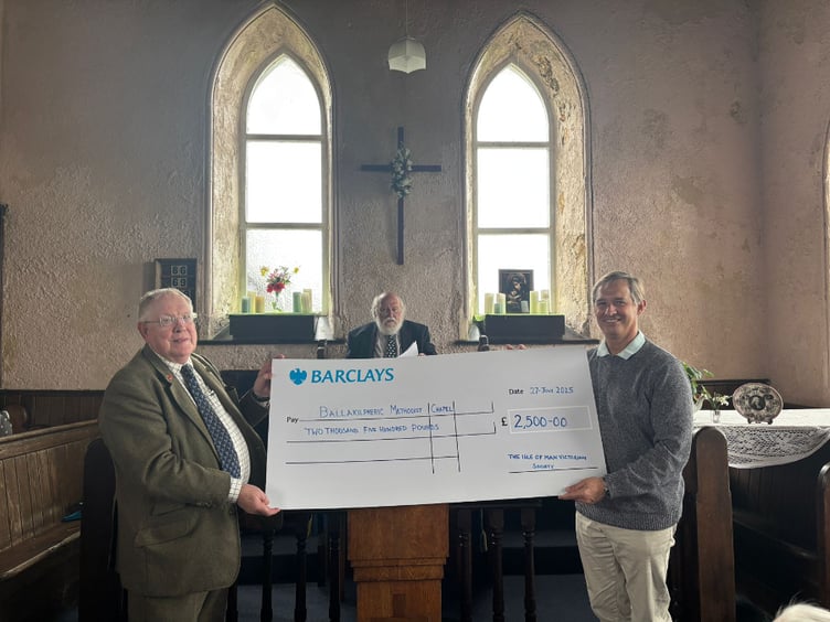 Members of the Victorian Society handing a cheque over to Ballakilpheric chapel