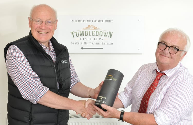 Lieutenant Governor Sir John Lorimer is presented with a bottle of Tumbledown gin by Falkland Islands Spirits managing director John Hellowell