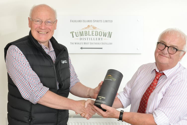 Lieutenant Governor Sir John Lorimer is presented with a bottle of Tumbledown gin by Falkland Islands Spirits managing director John Hellowell