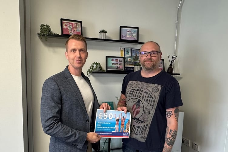Isle of Man Post Office’s commercial manager Ben Caley presents a voucher for £50 worth of foreign currency to Matthew Pressley of Barclays Bank