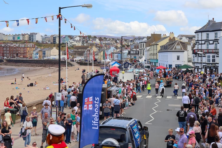 The RNLI boat passes through a packed out prom
