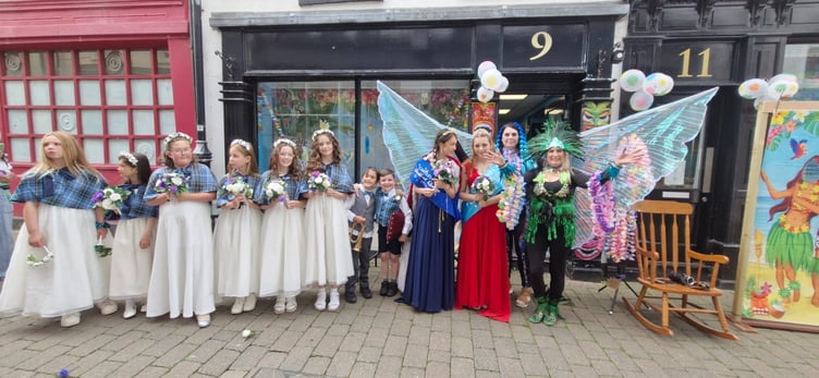 The Festival Queen and Princess are accompanied by flower girls in the streets of Castletown