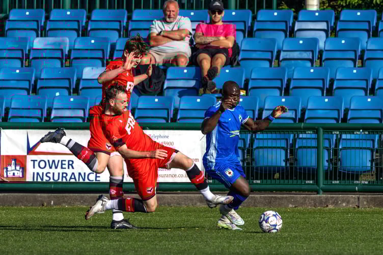 Luke Booth challenges a Glossop player during Saturday's hard-fought clash at the national stadium. Booth scored late on but couldn't prevent the visitors from winning 2-3 (Photo: Hannah McHugh)