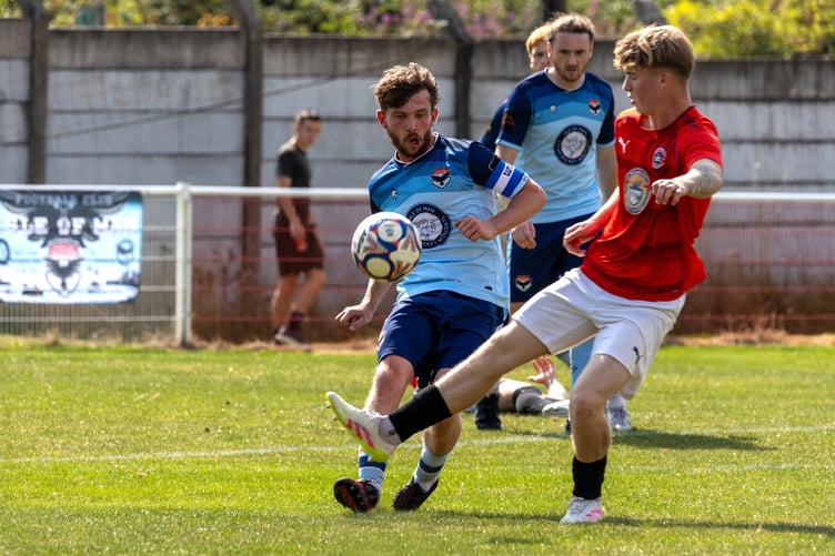 FC Isle of Man captain Danny Gerrard gets a pass away under pressure from an Abbey Hey opponent during the weekend's match (Photo: Hannah McHugh)