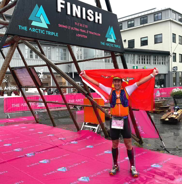 Dr Richard Callow celebrates with the Manx flag after winning the 2025 Lofoten Extreme Triathlon in Norway last week