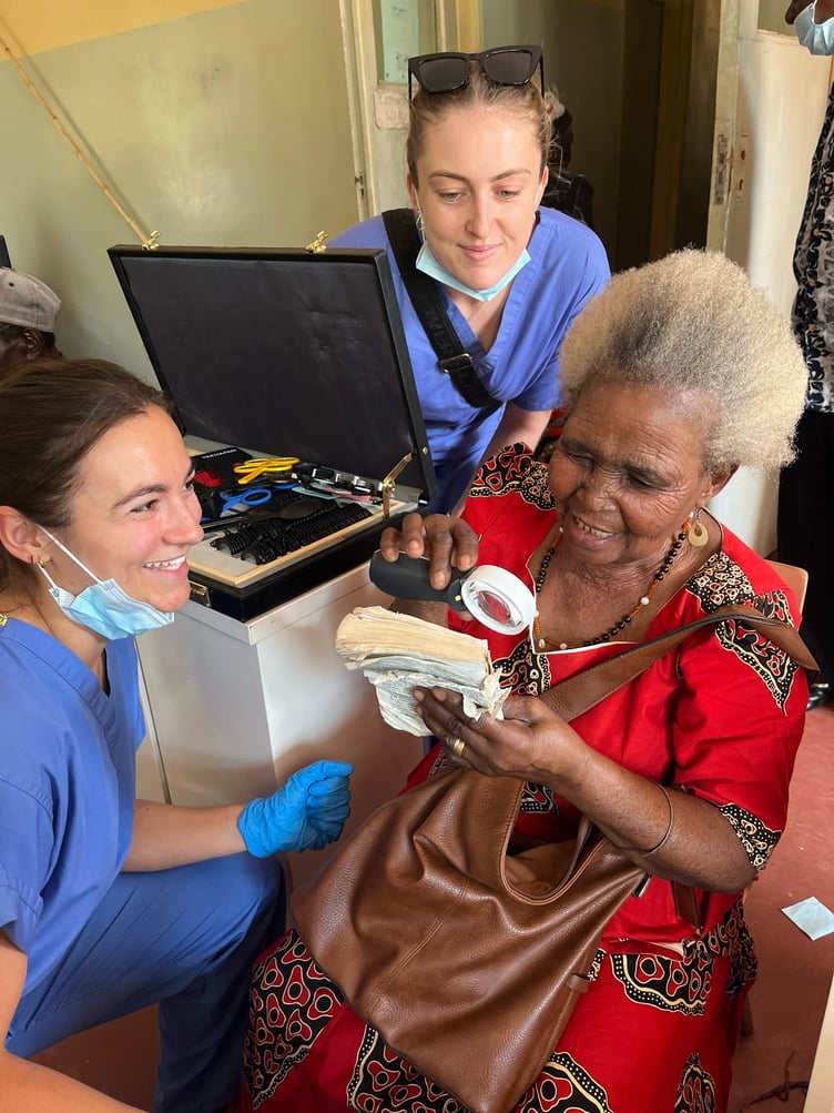Kelly McMullin (centre) with fellow supervisor Pheobe Withrington helping a patient in Malaw