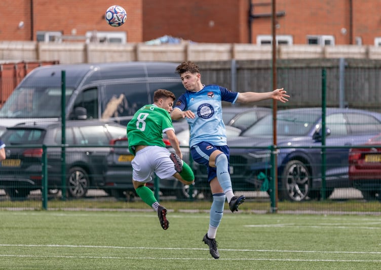FC Isle of Man's Callum Hudgeon heads clear from a Burscough opponent during Saturday's match in Ormskirk (Photo: Hannah McHugh)