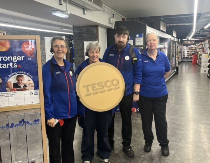 Staff at Tesco’s Castletown Isle of Man Express store with the Golden Grant banner