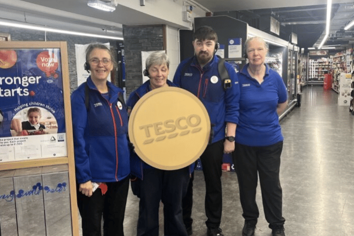 Staff at Tesco’s Castletown Isle of Man Express store with the Golden Grant banner
