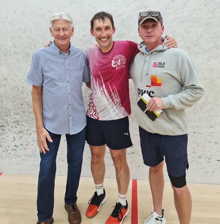 Ashley Sandyford-Sykes (centre) celebrates winning the annual Dave Karran Memorial Squash Competition alongside Brian Karran (left) and competition organiser Richard Cretney