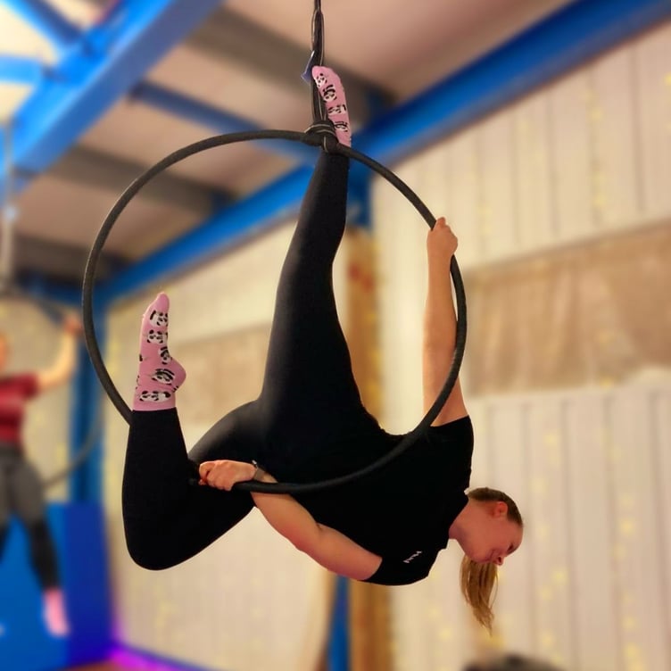 A student in an aerial hoop class