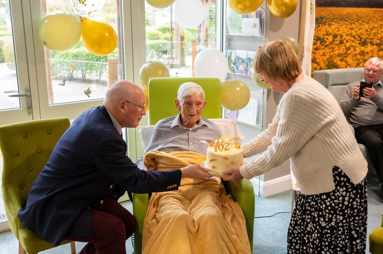 Jock being presented with a birthday cake on his 102nd birthday