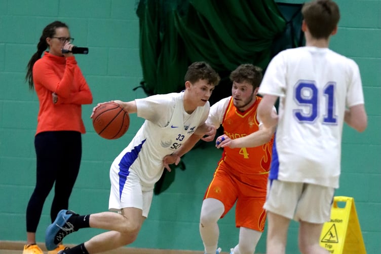 Cannons' Rowan Coulter drives to the hoop against Phoenix's Matt Jones while Alfie Garrett (No.91) set ups for the kick out (Photo: Martin Dunne)