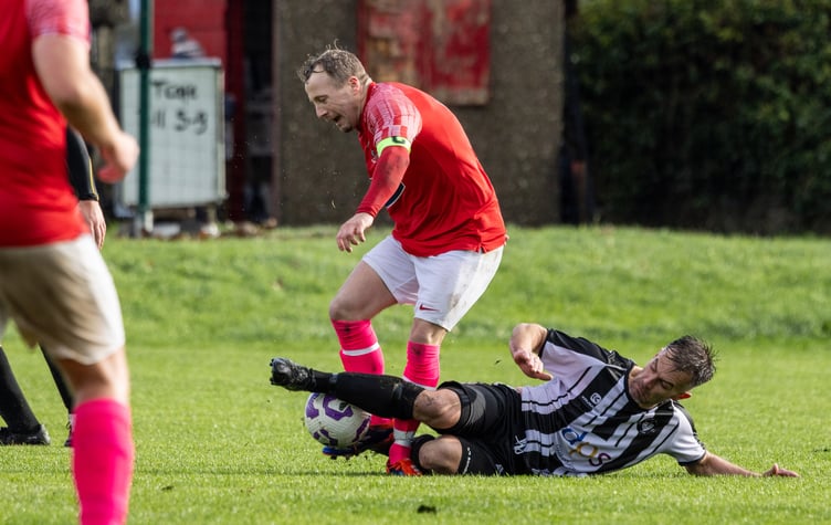 Colby's Phil Moody challenges Castletown captain Alex Crawley during Saturday's dramatic southern derby at The Stadium. Crawley completed the turnaround by scoring as the Mets came from 0-3 down to win 5-3 (Photo: Gary Weightman)