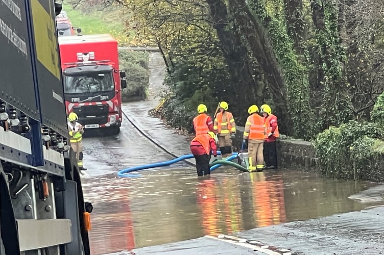 Fire crews pump out the flooded road at Brown Cow Hill