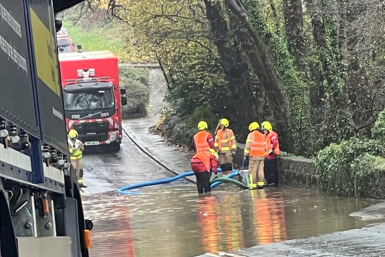 Fire crews pump floodwater away from the bottom of Brown Cow Hill