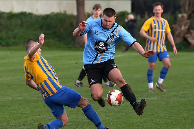 Rushen United's Ste Riding is challenged by a St John's player during last weekend's Premier League clash at Croit Lowey. The Saints won the match 2-1 to keep their faint Railway Cup hopes alive (Photo: Brian Goldie)