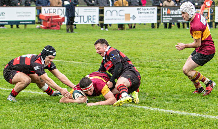 Douglas player Liam Kirkpatrick dives over between two defenders to score the first of his tries against Widnes on Saturday afternoon at Port-e-Chee (Photo: Richard Ebbutt)
