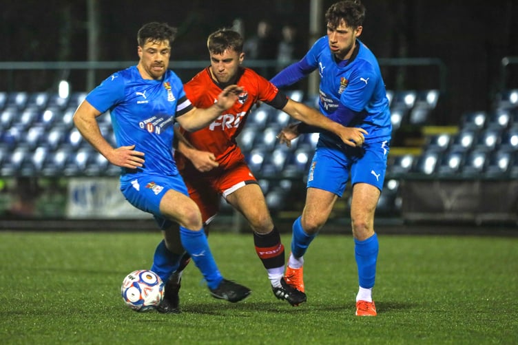 FC Isle of Man striker Joe Middleton gets between two Irlam players as he competes for the ball during Saturday's match at the Bowl (Photo: Hannah McHugh)