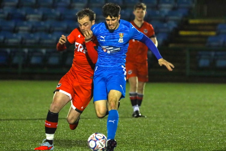 FC Isle of Man substitute Harry Best (left) tussles with an Irlam opponent as they jostle for the ball at the national stadium on Saturday evening (Photo: Hannah McHugh)