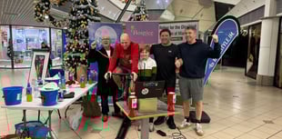 Friends cycle for 24 hours on exercise bike at shopping centre