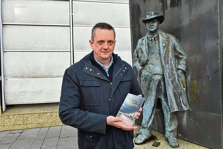 Conor Sharkey with a copy of his new book