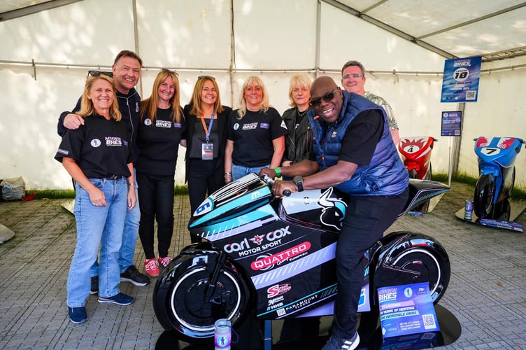 Carl Cox and the Mannin Cancers team at this year's TT, with Carl astride one of the of 15 model bikes that will be auctioned in May