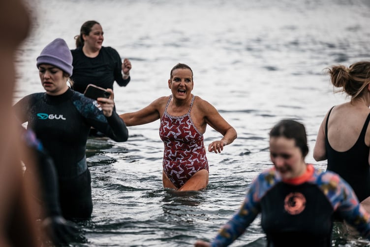 One swimmer proudly shows off her three legs costume during the dip at Port St Mary