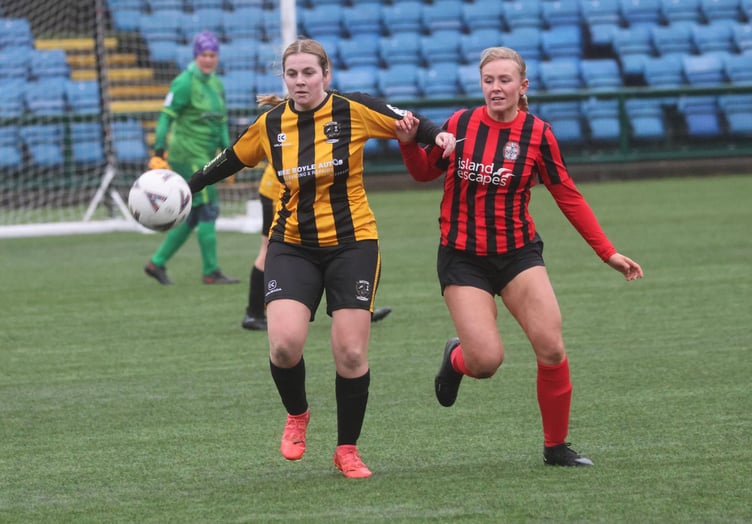 Rushen United's Shannon Primrose-Smith (left) battles with Malew's Abi Sutterby for the ball during Sunday's Floodlit Cup clash (Photo: Paul Hatton)