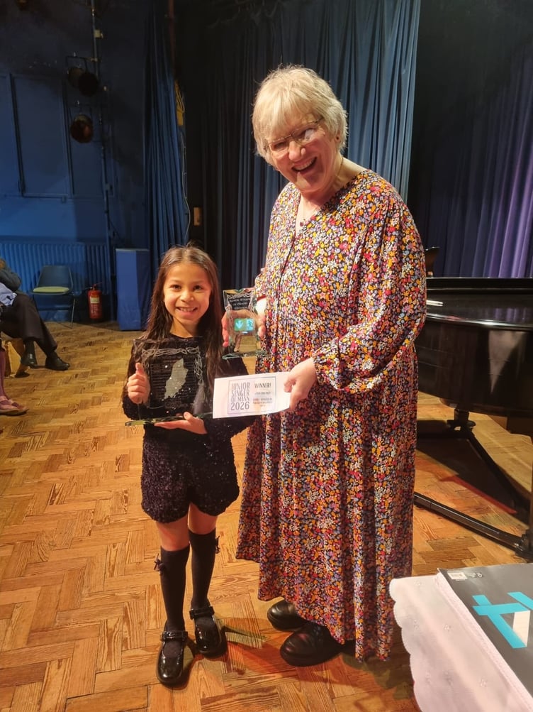 Frida Anderson receiving her winners prize from Angie Stewart